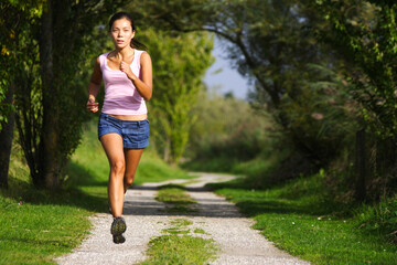 Running. Woman running at great speed. Freeze action image on beautiful forest path. Beautiful model.