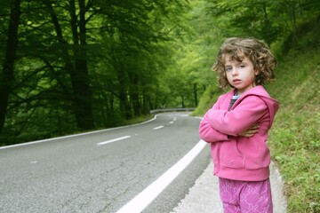 Cute little girl in a forest road dress in pink