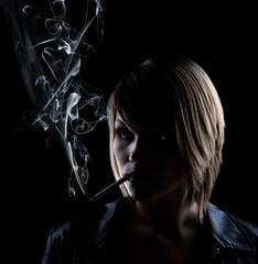 Fototapeta premium low key shot of a smoking woman on black background