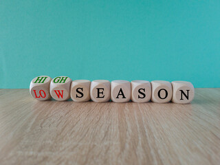 High or low season symbol. Concept words High season and Low season on wooden cubes. Beautiful wooden table blue background. Business high or low season concept. Copy space.