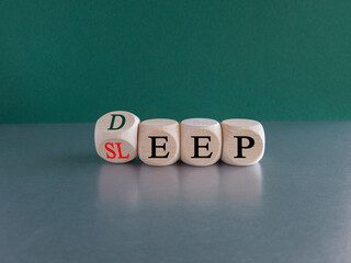 Sleep deep symbol. Turned a wooden cube with red words sleep deep. Beautiful grey table, green background, copy space. Healthy lifestyle, medical and sleep deep concept.