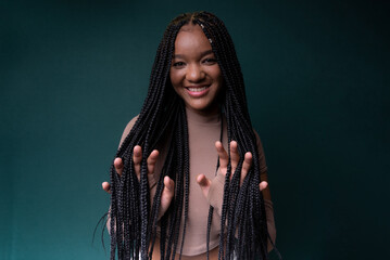 Young pretty black woman showing her hands through her braided hair.
