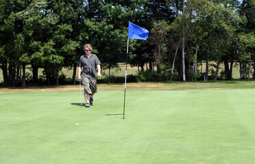 Obraz premium Man playing golf on the course.