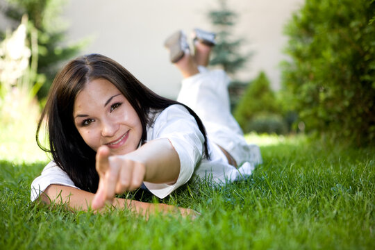 attractive brunette woman lying on grass