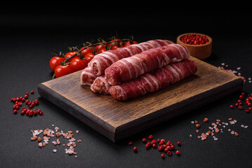 Raw minced meat wrapped in bacon with salt and spices or cevapcici