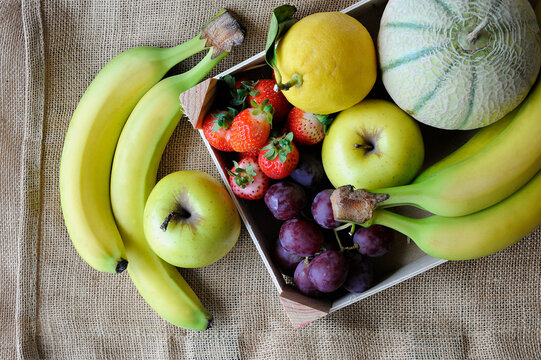Fruits bio bananes fraises pommes melon raisin sur toile de jute