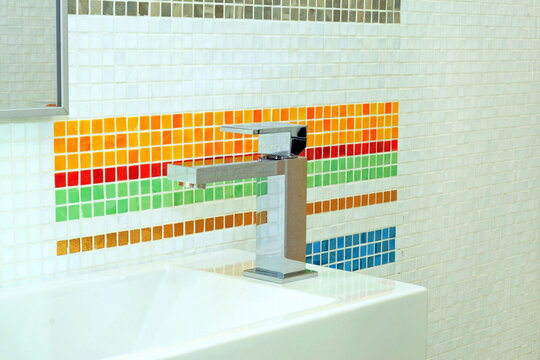 Basin and faucet in bathroom with colourful tiles