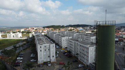 Fototapeta premium Visão aérea de um condomínio de prédios residenciais, destacando a arquitetura moderna e a organização da área urbana com diversos apartamentos e espaços comuns na cidade