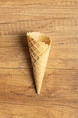 Empty wafer cone. Sweet ice cream cornet on wooden table. Top view.