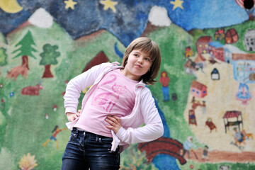 Obraz premium happy young girl posing and jumping with abstract urban style painting bacground begind