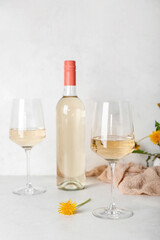 Fototapeta Bottle and glasses of dandelion wine on white table obraz