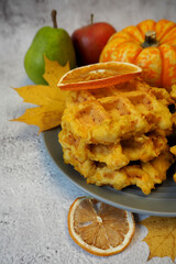 gluten free pumpkin waffles.  lie on a gray plate on a gray background.  breakfast diet