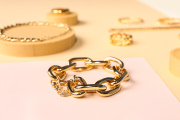 Decorative podiums with golden rings and bracelets on color background