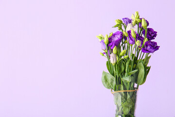 Vase with eustoma flowers on lilac background