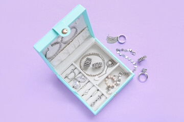 Organizer with stylish jewelry on lilac background