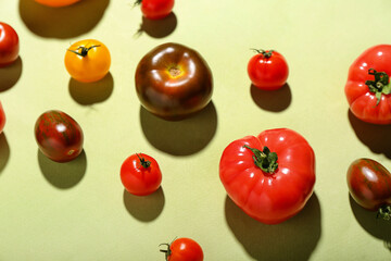 Different fresh tomatoes on light green background
