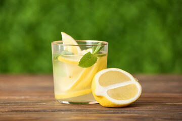 Glass with fresh lemonade on wooden table