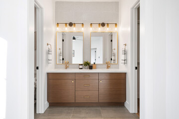 Modern double sink bathroom with a mosaic tiled wall running along the backside 