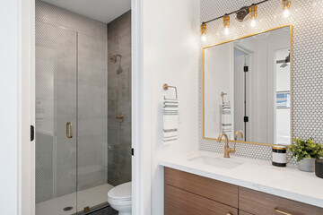 mosaic tiled bathroom with gold accents throughout.