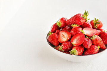Bowl with fresh strawberries on white background