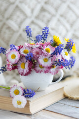 Bouquet of daisy with pink flowers in a ceramic white mug, wooden background. Romantic still life, summer or spring inspiration, cozy home decor. Greeting card for birthday, anniversary, Mother's Day