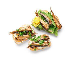 Tasty sandwiches with canned smoked sprats on white background