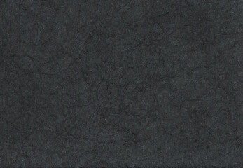 Textured black paper with rough wrinkled lines. Crumpled black paper background.