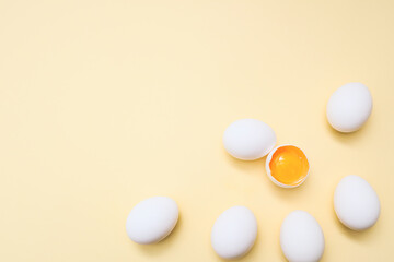 White eggs and egg yolk on the yellow background.
