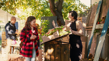 Diverse farmers helping customers with produce and healthy food, vendors selling homegrown fruits and veggies. Consumers talking to farmers about organic products, stall holders.