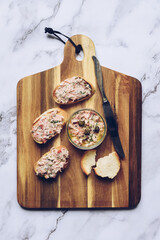 Salmon rillettes, mousse, pate and toasts on wooden background