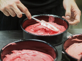 chef preparing white pink red cake creamy mixtures doughs to bake in the oven