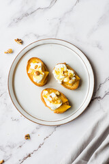 Baguette slices with cream cheese, persimmon, honey, and nuts