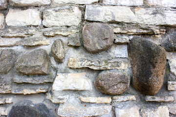 Stone wall background stones of different size.Authentic wall made of old natural stones.