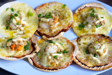 Grilled scallops shell with butter and garlic on white plate