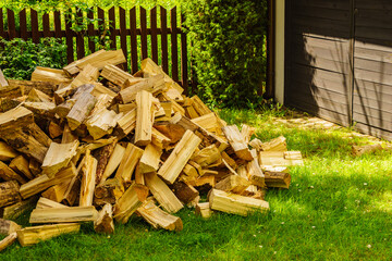 Stack of firewood on green grass.