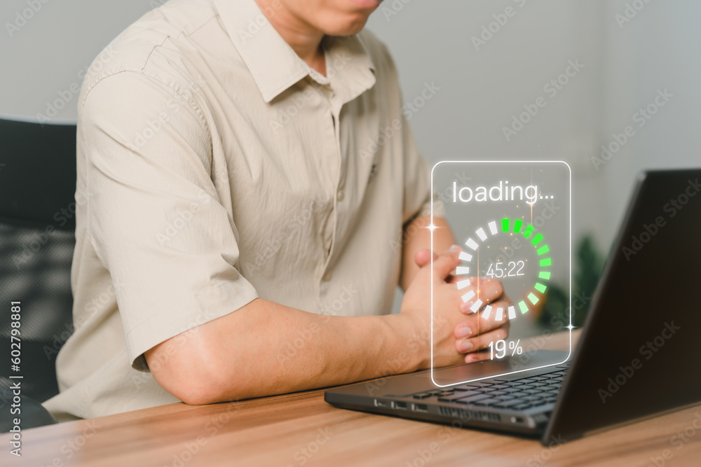 Poster Adult man using a laptop computer for download and update software and waiting to loading digital file data form website, very slow internet form wifi. Concept of waiting for load of loading symbol.