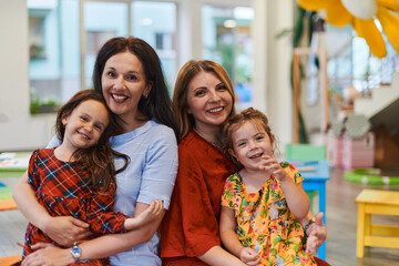 A child hugging a teacher in a modern kindergarten
