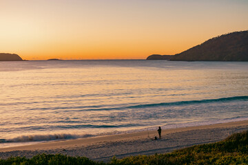 Man fishing on the beach, early morning at Jimmy's Beach at Hawk's Nest, NSW Australia
