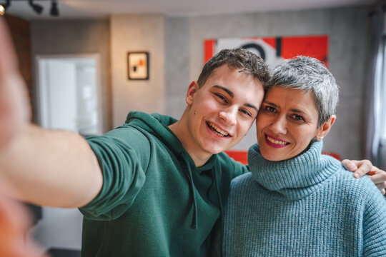 teenager boy young man and mature woman mother and son take selfie photos self portraits at home