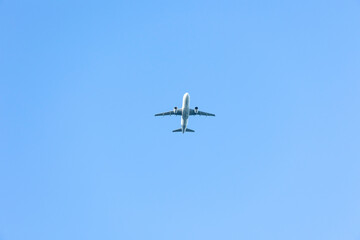 A jet plane flying in a blue sky between clouds. Transportation. Air travel.