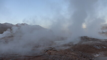 Vista panorâmica do Geyser del Tatio no Chile, com vapores termais subindo no ar, criando uma paisagem deslumbrante e única no deserto de Atacama