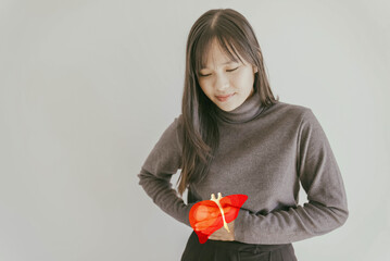 Asian young woman holding healthy liver, organ donation, hepatitis vaccination, liver cancer...