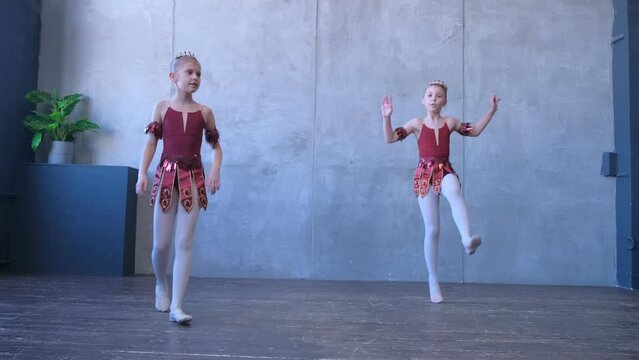 A girls dancer in a ballet school is learning to dance. Little ballerinas in training in a dance costume. Children's ballet school. 4K