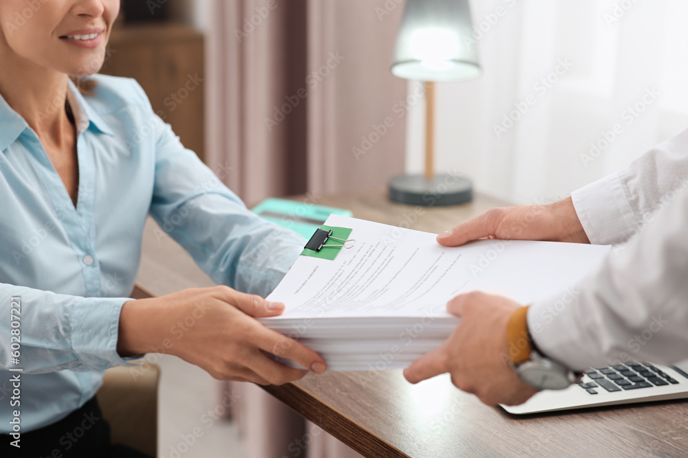 Wall mural Woman giving documents to colleague in office, closeup