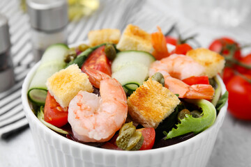 Tasty salad with croutons, tomato and capers on table, closeup