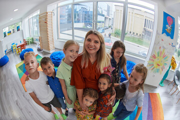 Children in a preschool institution standing in the classroom together with the teacher