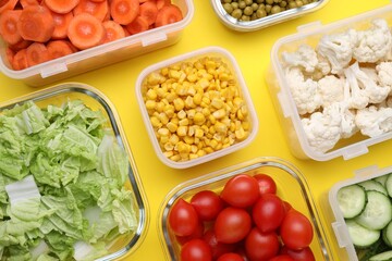 Plastic and glass containers with different fresh products on yellow background, flat lay