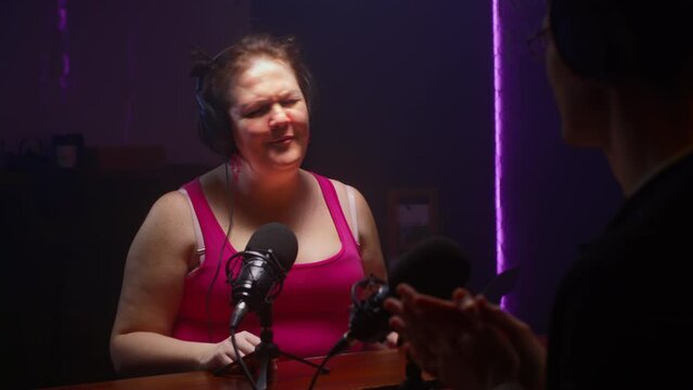 Podcast about body positivity. Chubby fat woman speaks into a microphone, sings a song live. A conversation with a journalist about self-acceptance, diet. Concept of diverse beauty and lifestyle