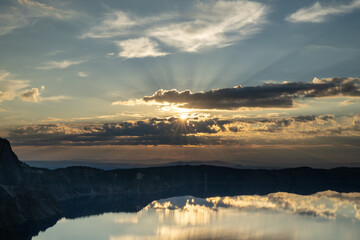 Sunburst Breaks Through Dark Clouds Over Crater Lake Just After Sun Rise