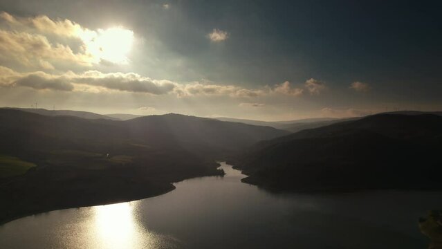 Colorful and dreamy aerial of a lake in the mountains at sunrise in Basilicata, Lake of Acerenza, Italy 4K drone